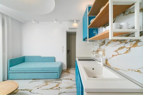 une cuisine avec un canapé bleu et un évier dans l'établissement Athina Palace Luxurious Appartments, à Potos