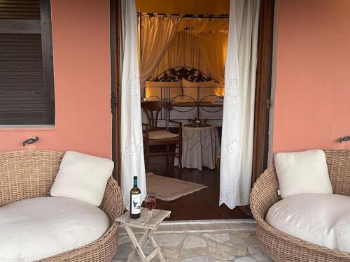 a living room with two chairs and a table with a bottle of wine at ZenTerra Country house with prive swimming pool and view in Matésion