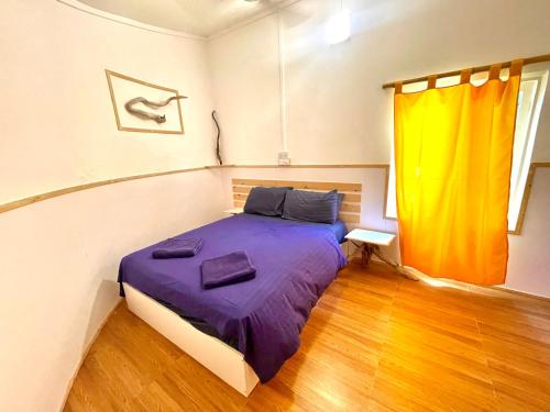 a bedroom with a bed with purple sheets and a window at Thulusdhoo Garden Villa in Thulusdhoo