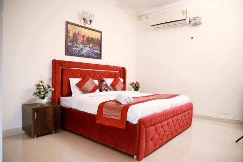 a bedroom with a large red bed in a room at Divine India Service Apartment 2Bhk, 2A Saket in New Delhi