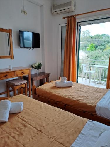 a hotel room with two beds and a window at Evridiki Apartments in Mesongi