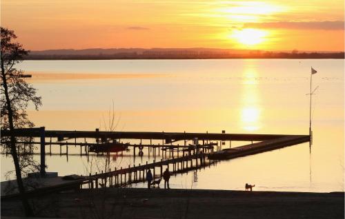 a dock on a body of water with a sunset at Nice Apartment In Lembruchdümmer See in Lembruch