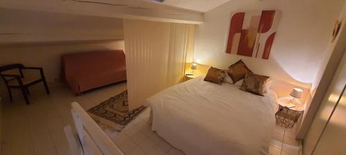 een slaapkamer met een wit bed met 2 kussens bij Duplex Fréjus Plage, 2' plage et commerces in Fréjus