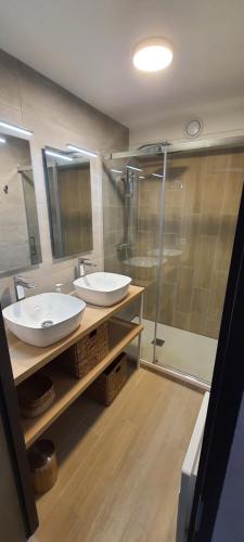 une salle de bain avec deux lavabos et une douche dans l'établissement Duplex Fréjus Plage, 2' plage et commerces, à Fréjus