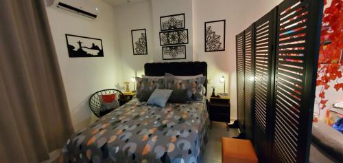 1 dormitorio con 1 cama y algunas fotos en la pared en StudioRD Copacabana 250m da praia esquina com a Rua do Copacabana Palace Rodolfo Dantas, en Río de Janeiro