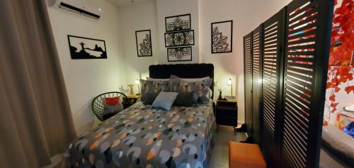 a bedroom with a bed and some pictures on the wall at StudioRD Copacabana 250m da praia esquina com a Rua do Copacabana Palace Rodolfo Dantas in Rio de Janeiro