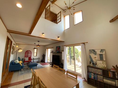 a living room with a table and a tv at 貸別荘Casa de Campo 2SLDK别墅 駐車場 芝生東屋付き BBQ 大室山と海遠望伊豆高原5分 in Ito