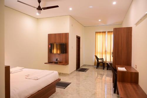 a hotel room with a bed and a desk at KCG Residency in Mysore