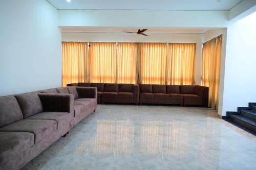 a living room with two brown couches at KCG Residency in Mysore