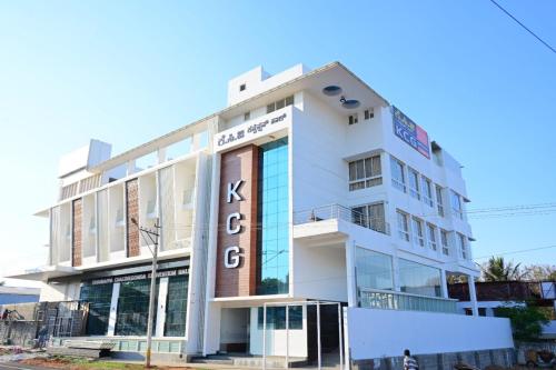 a white building with a sign on it at KCG Residency in Mysore