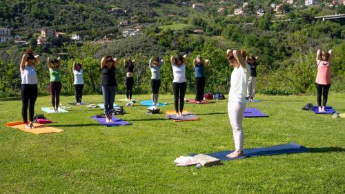 a group of people doing yoga in the grass at La Casa Di Menny Maison de Campagne in Moneglia