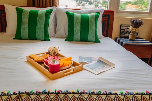 een dienblad met eten bovenop een bed bij Bòn Stay Đà Lạt in Da Lat