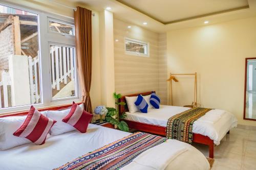een slaapkamer met 2 bedden en een raam bij Bòn Stay Đà Lạt in Da Lat