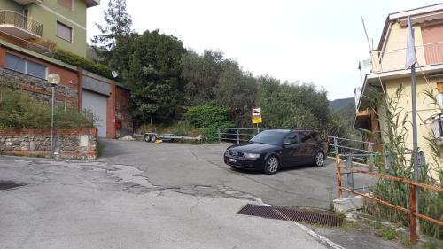 a car parked in a parking lot next to a building at La Casa Di Menny Maison de Campagne in Moneglia