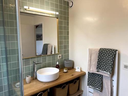 La salle de bains est pourvue d'un lavabo et d'un miroir. dans l'établissement La terrasse du golf, à Port-en-Bessin-Huppain