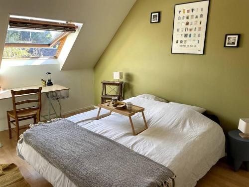 a bedroom with a bed and a table and a desk at La terrasse du golf in Port-en-Bessin-Huppain