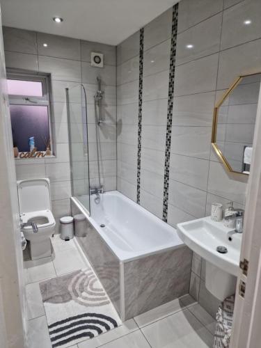 a bathroom with a tub and a toilet and a sink at Central Watford Modern Apartment - Travellers & Contractors Welcomed in Watford