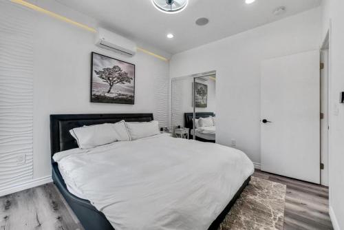 a bedroom with a large bed with white sheets at Luxury 2 bedroom villa in Huntington Beach