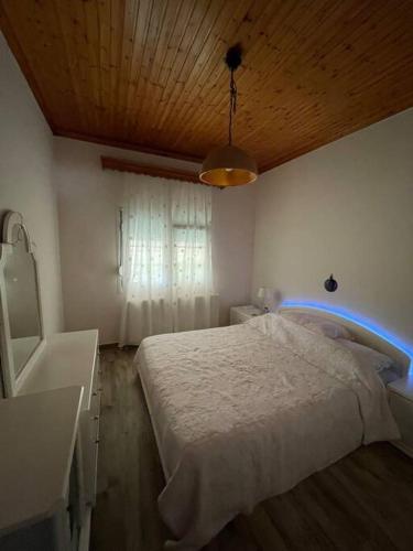 - une chambre avec un lit blanc et un plafond en bois dans l'établissement Carefree Dreams : Cottage in Flogita Chalkidiki, à Flogita