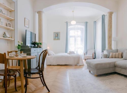 a white living room with a bed and a table at CYPRIAN apartment in Banská Štiavnica