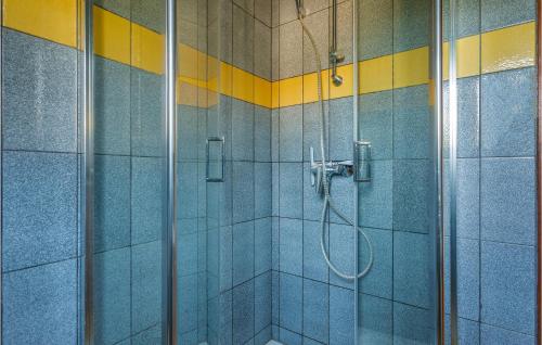 a bathroom with a shower with blue and yellow tiles at Amazing Apartment In Njivice With Kitchen in Njivice