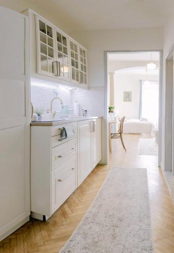 a white kitchen with a sink and a counter at CYPRIAN apartment in Banská Štiavnica