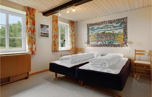 een slaapkamer met 2 bedden en een schilderij aan de muur bij Hjvang in Klemensker