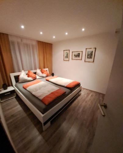 a bedroom with a bed with orange and white sheets at Come a casa in Nikelsdorf