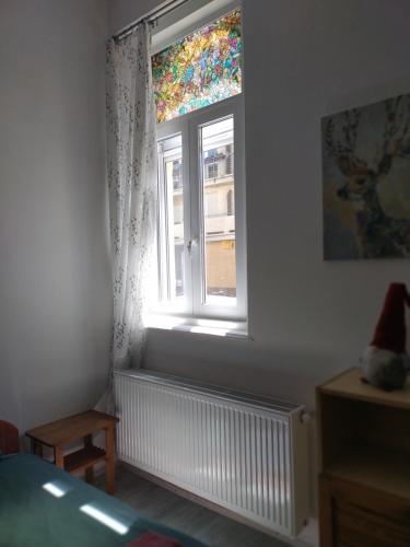 a bedroom with a window and a radiator at Old Buda Family Home in Budapest