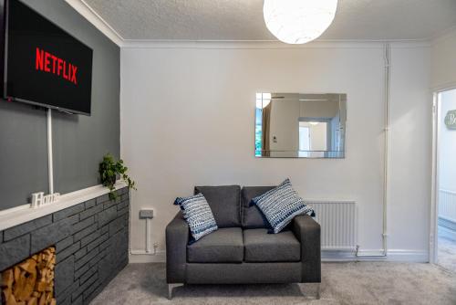 a living room with a couch and a fireplace at Smart Tv's in all 4 Bedrooms for your Convenience! in Port Talbot