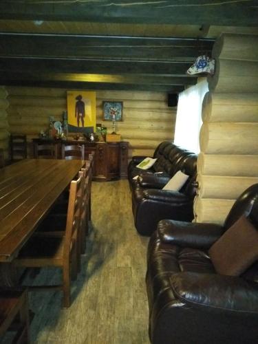 a living room with leather couches and a wooden table at BRB Park Hotel in Vizhenka