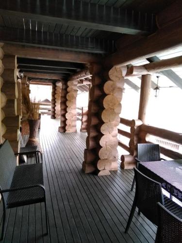 a deck of a log cabin with chairs and tables at BRB Park Hotel in Vizhenka