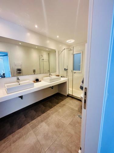 a bathroom with two sinks and a large mirror at Seaview & Jacuzzi Villa Sea View in Mikonos