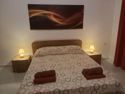 - une chambre avec un lit avec deux lampes et un tableau dans l'établissement Seagull Flats, à Marsalforn