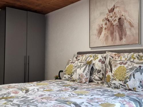 una camera da letto con un letto con cuscini e un dipinto di Babylone a Orvin