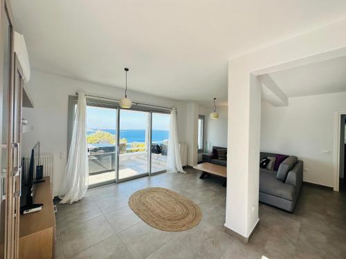 a living room with a couch and a view of the ocean at Seaview & Jacuzzi summer residence in Mýkonos City