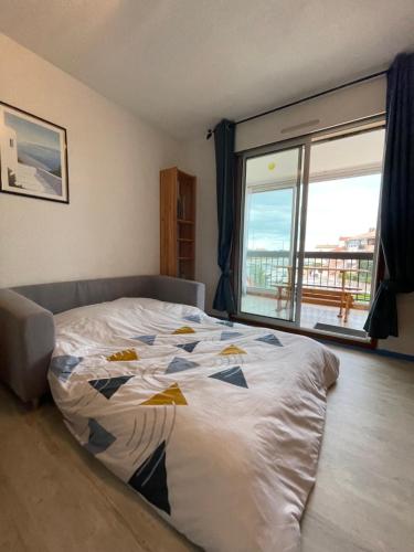 a bedroom with a bed with a view of the ocean at « L’hispaniola » avec sa vue sur la marina in Saint-Cyprien