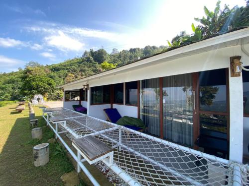a house with a large deck with chairs on it at De Pointé Resort & Resto in Campaka