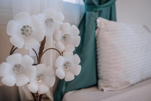 a vase filled with white flowers next to a pillow at Swiss Royal DAHAB in Dahab