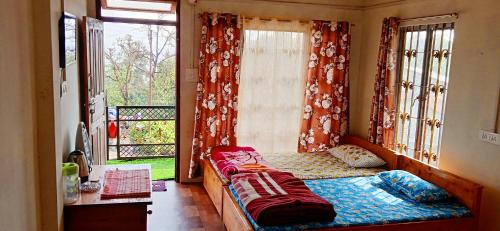 Schlafzimmer mit einem Bett vor einem Fenster in der Unterkunft Well Spring Homestay in Kalimpong