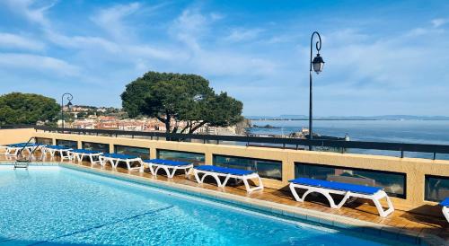 a swimming pool with lounge chairs and the water at Vue exceptionnelle sur la baie de Collioure in Collioure