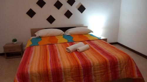 Una cama con una manta colorida y almohadas. en Bayekou, en Paceco