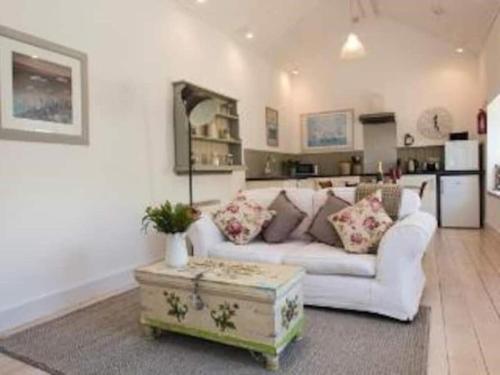 a living room with a white couch and a table at The Flower House in Madron