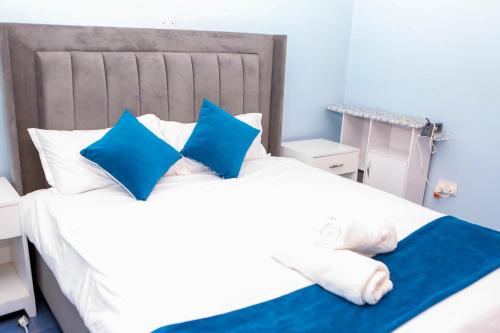 a bedroom with a bed with blue and white pillows at Tiamcy homes in Kisumu