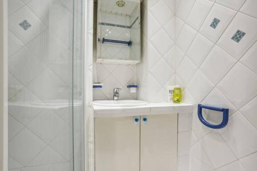 een witte badkamer met een wastafel en een douche bij Modern flat in Paris - Heart of XVIème in Parijs