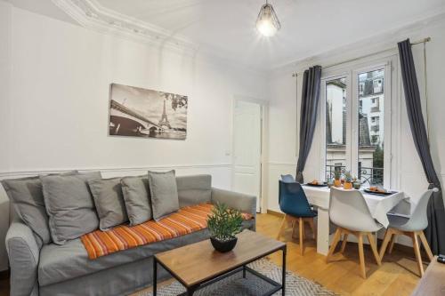 un salon avec un canapé et une table dans l'établissement Modern flat in Paris - Heart of XVIème, à Paris