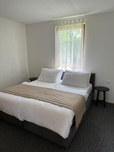 a bedroom with a large bed with a window at Bungalows SPORT CENTAR in Međugorje