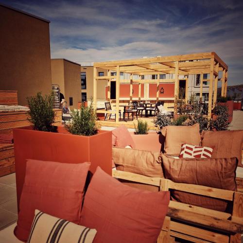 a rooftop patio with couches and a pavilion at Afterwork Hotel in Etoy