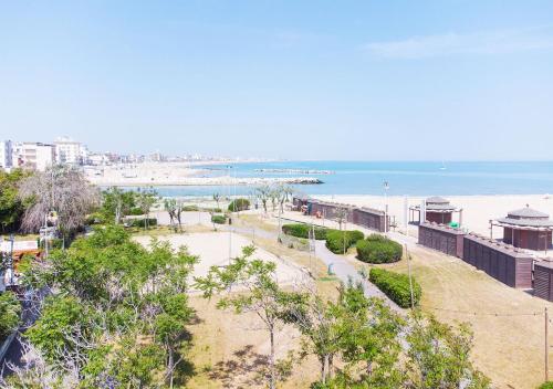 un parque cerca de la playa con el océano en el fondo en Hotel Paloma, en Rímini