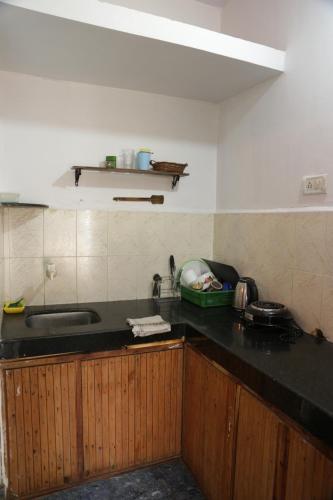 a kitchen with a sink and a black counter top at Dreamcatcher House & Hostel at Arambol Beach in Arambol